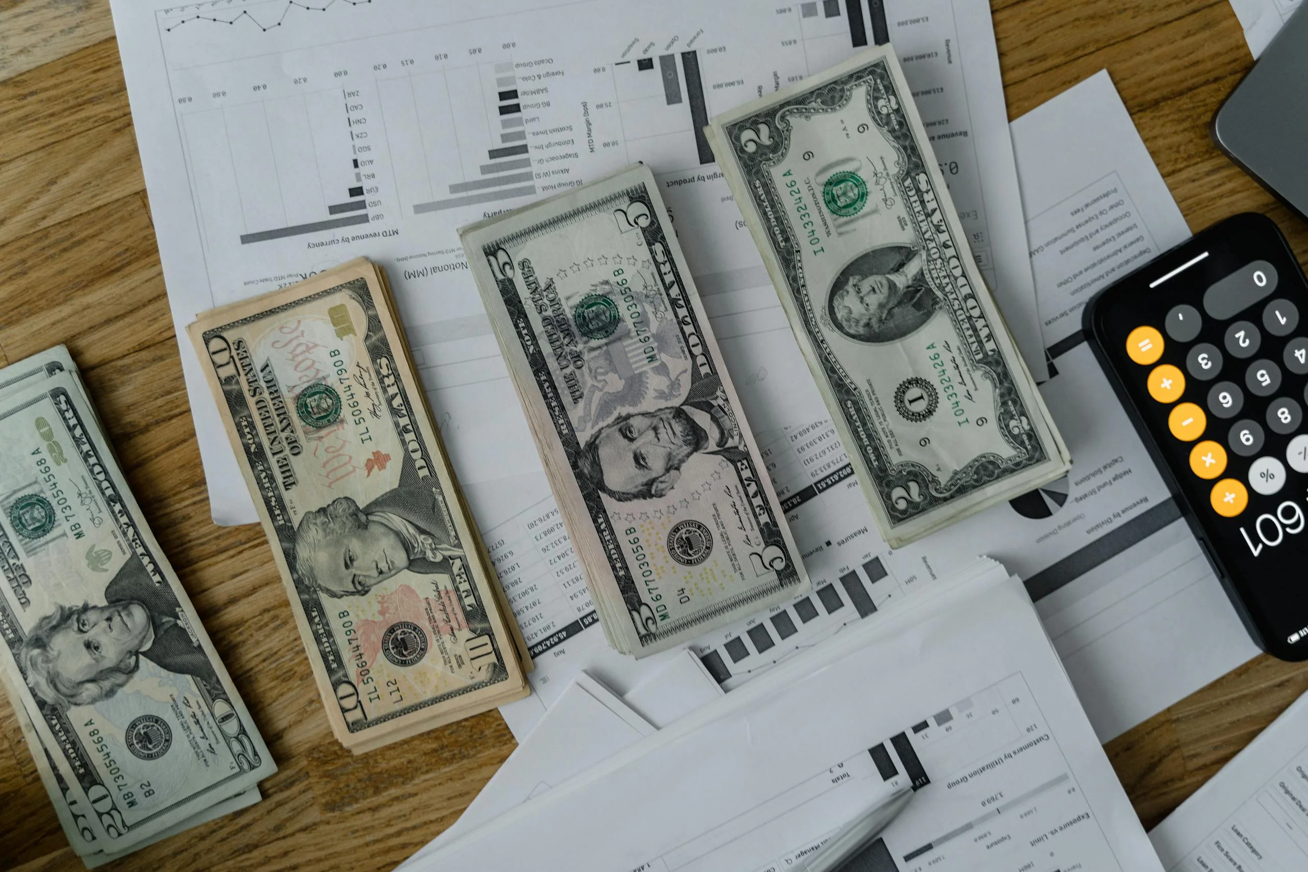 A workspace setup featuring cash, documents, and a calculator symbolizing financial analysis and budgeting.